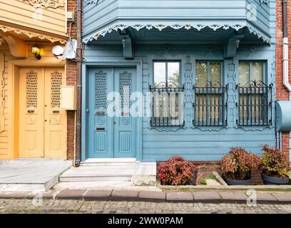 Affascinanti case blu e gialle con porte decorate in legno e finestre ornate in ferro battuto. Le case si trovano in uno stretto vicolo adatto nel quartiere Kuzguncuk, nel quartiere Uskudar, Istanbul, Turchia Foto Stock