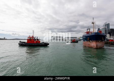 Due rimorchiatori aiutano la nave da carico Rangitata a scendere dal molo di Auckland. Foto Stock