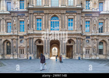 I visitatori passeggiano attraverso la Cour Carree al Louvre di Parigi. Foto Stock