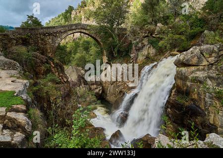 Vista dell'antico Ponte romano Mizarela, o Ponte del Diavolo con un bellissimo arco e una pittoresca cascata, presso il Parco Nazionale Peneda Geres a Portu Foto Stock