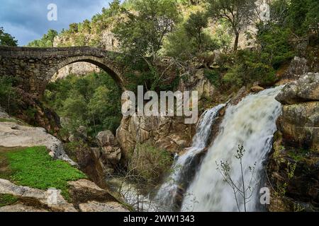 Vista dell'antico Ponte romano Mizarela, o Ponte del Diavolo con un bellissimo arco e una pittoresca cascata, presso il Parco Nazionale Peneda Geres a Portu Foto Stock