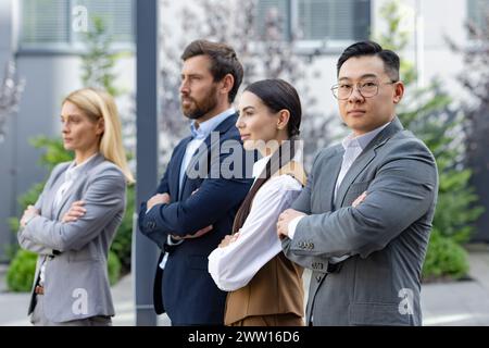 Un gruppo eterogeneo di professionisti si trova in una posizione sicura all'aperto, riflettendo il lavoro di squadra e il successo. Foto Stock