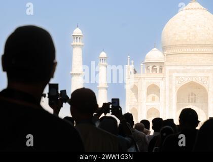 Silhouette di turisti che scattano foto con i telefoni all'ingresso principale del Taj Mahal Foto Stock