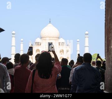 I turisti scattano foto con il telefono al Taj Mahal dall'ingresso principale di Agra Foto Stock