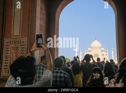 I turisti scattano foto con il telefono al Taj Mahal dall'ingresso principale di Agra Foto Stock