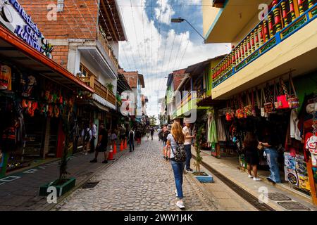 Guatape, Colombia - 16 gennaio 2023: Passeggiate turistiche lungo la strada pedonale piena di negozi nel centro commerciale della città Foto Stock