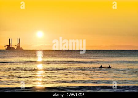 La Vole Au Vent Offshore supply Ship Jack Up è ancorata nel Mare del Nord al largo di Blyth all'alba con nuvole dorate e sole appena sopra e golde Foto Stock