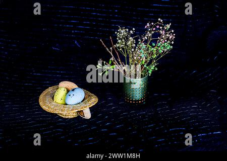 Rami fioriti di un albero da frutto e uova di Pasqua su sfondo scuro. Domenica di Pasqua Foto Stock