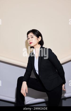 Una donna con un vestito nero e una camicia bianca Foto Stock