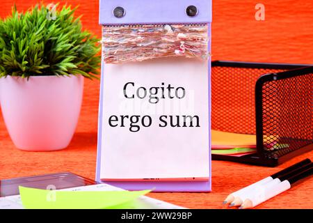 Le parole Cogito Ergo Sum o penso quindi che io sia è scritto su un calendario desktop con foglie sciolte Foto Stock