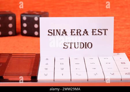 Sina era il più grande studio di studio significa senza rabbia e dipendenza su un biglietto da visita bianco su una calcolatrice su sfondo arancione Foto Stock