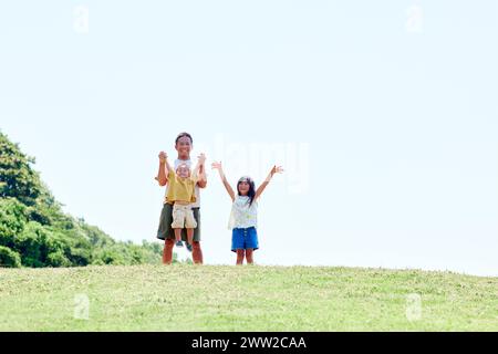 Un uomo e due bambini in cima a una collina Foto Stock