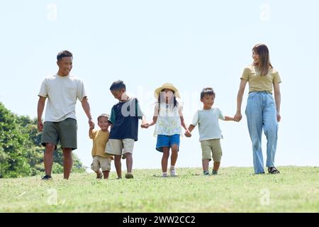 Una famiglia che cammina su un campo erboso Foto Stock