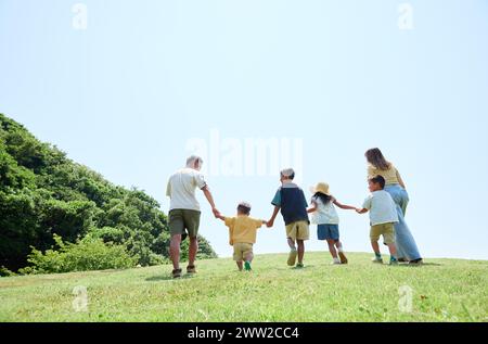 Vista posteriore della famiglia che cammina insieme nel parco Foto Stock