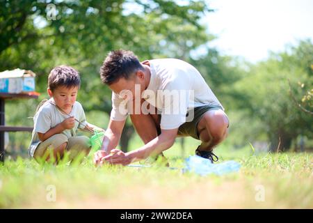 Un uomo e un ragazzo che giocano nell'erba Foto Stock