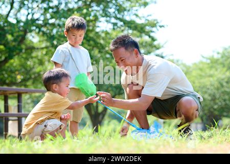 Un uomo e dei bambini che giocano nell'erba Foto Stock