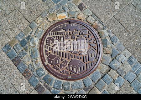 Alesund, Norvegia - 06 07 2022: Coperchio in metallo pesante di un tombino nel centro della città di Alesund, una popolare destinazione di viaggio in Norvegia. Foto Stock