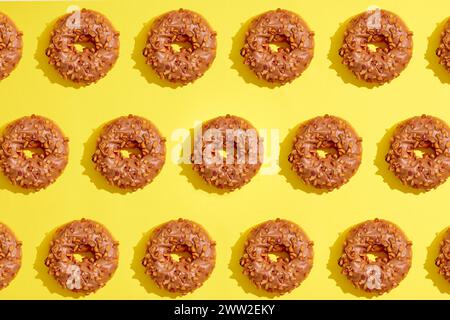 Un modello di ciambelle su sfondo giallo Foto Stock