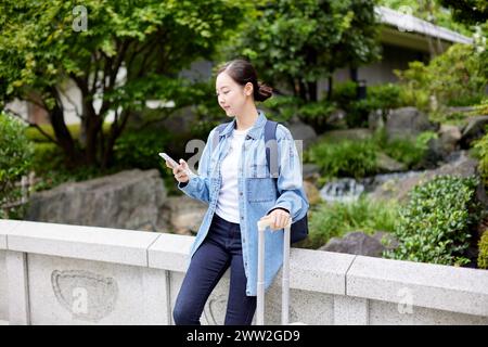 Donna asiatica utilizza lo smartphone Foto Stock
