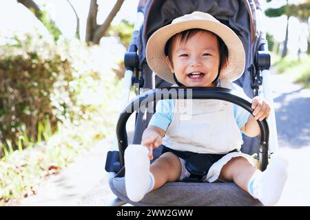 Un bambino sorridente in un passeggino Foto Stock