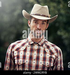 Uomo, ritratto e abito da cowboy all'aperto, cultura occidentale e ranch di campagna in Texas. Uomo, cappello e flanella tendenza per l'estetica degli agricoltori Foto Stock