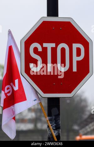 Magdeburgo, Germania. 21 marzo 2024. Una bandiera Verdi union è appesa a un segnale di stop all'ingresso di un deposito MVB. I negoziati tra l'unione Verdi e l'associazione dei datori di lavoro comunali sono falliti nel terzo turno. Verdi ha quindi invitato i dipendenti delle aziende di trasporto locali a interrompere il lavoro dal giovedì alla domenica. Crediti: Klaus-Dietmar Gabbert/dpa/Alamy Live News Foto Stock