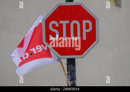 Magdeburgo, Germania. 21 marzo 2024. Una bandiera Verdi union è appesa a un segnale di stop all'ingresso di un deposito MVB. I negoziati tra l'unione Verdi e l'associazione dei datori di lavoro comunali sono falliti nel terzo turno. Verdi ha quindi invitato i dipendenti delle aziende di trasporto locali a interrompere il lavoro dal giovedì alla domenica. Crediti: Klaus-Dietmar Gabbert/dpa/Alamy Live News Foto Stock