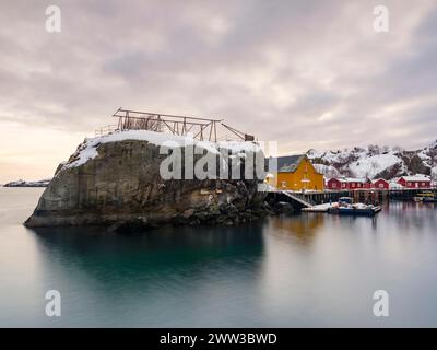 Grande roccia nel porto dell'autentico villaggio di pescatori di Nusfjord, Flakstadoya, Lofoten, Norvegia Foto Stock