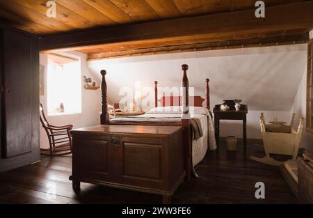 Letto matrimoniale a baldacchino e vecchia cassettiera in legno nella camera principale al piano superiore all'interno della vecchia casa del 1785, Quebec, Canada Foto Stock