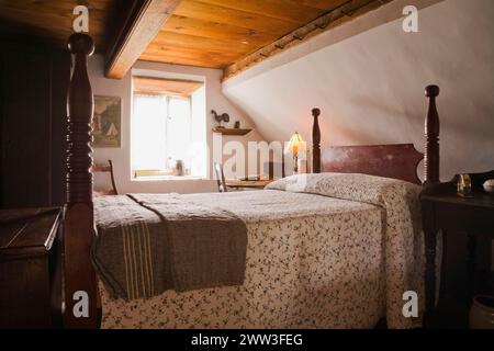 Letto matrimoniale a baldacchino e vecchia cassettiera in legno nella camera principale al piano superiore all'interno della vecchia casa del 1785, Quebec, Canada Foto Stock