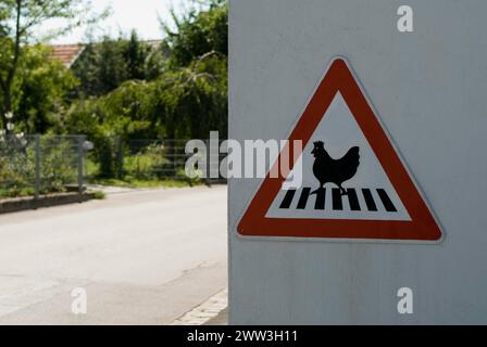 Cartello segnaletico che attraversa la gallina sulla passeggiata in un piccolo villaggio a nord di Monaco, vicino a Pfaffenhofen, Baviera, Germania Foto Stock