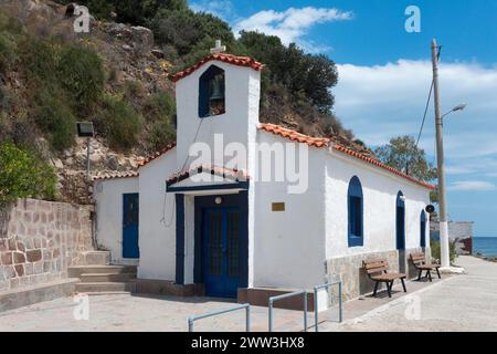 Piccola cappella bianca con accenti blu situata vicino a una strada tranquilla, alla chiesa di Santa Croce, a Poros, all'isola di Poros, alle isole Saroniche, Peloponneso, Grecia Foto Stock