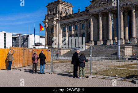 Turisti che si trovano presso la recinzione di costruzione di fronte all'edificio del Reichstag, Berlino, Germania Foto Stock