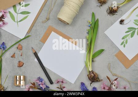 Tabella con foglio di carta vuoto da compilare. Preparati per piantare fiori in primavera. Foto Stock