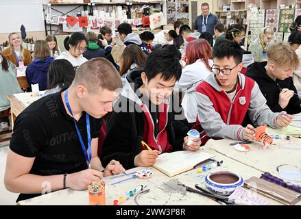 Qingdao, la provincia cinese dello Shandong. 21 marzo 2024. Gli studenti cinesi e tedeschi sperimentano la pittura delle statuette della "tigre d'argilla" nella Qingdao No. 9 High School a Qingdao, nella provincia di Shandong della Cina orientale, 21 marzo 2024. Gli studenti delle scuole superiori di Magdeburgo, in Germania, che hanno fatto una visita amichevole alla Qingdao No. 9 High School nella provincia di Shandong, hanno avuto l'esperienza di realizzare opere d'arte del patrimonio culturale immateriale cinese e hanno imparato la cultura cinese tradizionale con gli studenti cinesi. Crediti: Li Ziheng/Xinhua/Alamy Live News Foto Stock