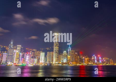 Spettacolo di luci notturne di Hong Kong sui grattacieli vicino alla baia. Foto Stock