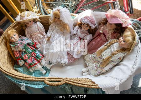 bambole in porcellana antica con culla in vimini blu, nella vetrina del negozio Foto Stock