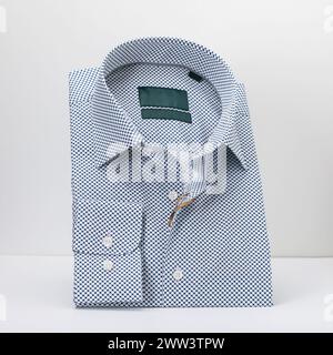 Classica camicia a pois da uomo ripiegata con manica lunga su sfondo chiaro Foto Stock