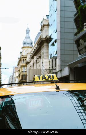 Cartello taxi con l'edificio sullo sfondo. Taxi della città di Rosario. Contesto di insicurezza a causa dell'attuale violenza sulla droga in Argentina Foto Stock