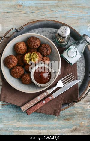 Piatto di falafel con spezie e zuppa su vassoio di metallo su sfondo di legno, vista dall'alto Foto Stock