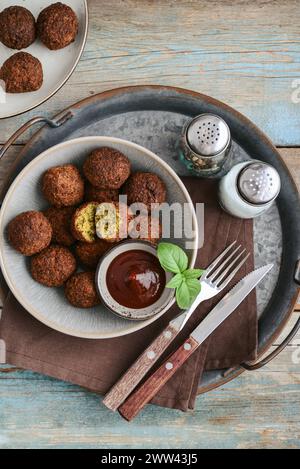Piatto di falafel con spezie e zuppa su vassoio di metallo su sfondo di legno, vista dall'alto Foto Stock