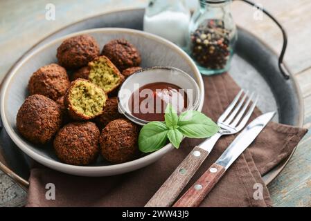 Piatto di falafel con spezie e zuppa su vassoio di metallo su fondo di legno, primo piano Foto Stock