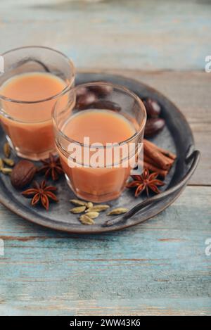 Bevanda indiana tradizionale - tè masala con spezie su vassoio di metallo su sfondo di legno Foto Stock