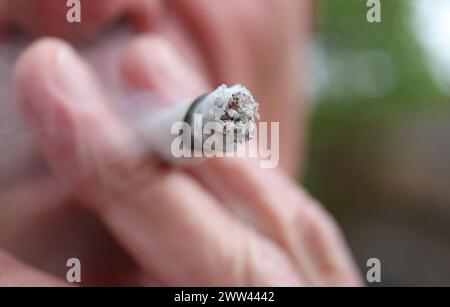 Augusta, Germania. 21 marzo 2024. Un uomo fuma uno spinello. Il Bundestag ha deciso di introdurre il rilascio controllato il 1° aprile. Tuttavia, la decisione del Bundesrat è ancora pendente. Non c'è ancora una netta maggioranza nel Bundesrat per la controversa legalizzazione della cannabis venerdì prossimo, 22 marzo. Crediti: Karl-Josef Hildenbrand/dpa/Alamy Live News Foto Stock