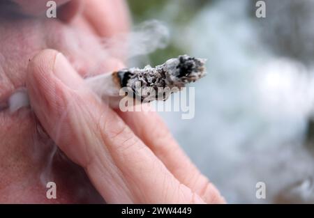 Augusta, Germania. 21 marzo 2024. Un uomo fuma uno spinello. Il Bundestag ha deciso di introdurre il rilascio controllato il 1° aprile. Tuttavia, la decisione del Bundesrat è ancora pendente. Non c'è ancora una netta maggioranza nel Bundesrat per la controversa legalizzazione della cannabis venerdì prossimo, 22 marzo. Crediti: Karl-Josef Hildenbrand/dpa/Alamy Live News Foto Stock