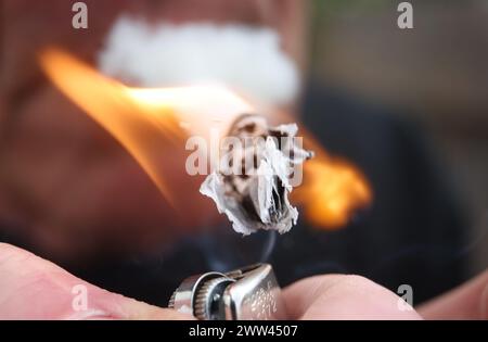 Augusta, Germania. 21 marzo 2024. Un uomo illumina uno spinello. Il Bundestag ha deciso il rilascio controllato a partire dal 1° aprile. Tuttavia, la decisione del Bundesrat è ancora pendente. Non c'è ancora una netta maggioranza nel Bundesrat per la controversa legalizzazione della cannabis venerdì prossimo, 22 marzo. Crediti: Karl-Josef Hildenbrand/dpa/Alamy Live News Foto Stock
