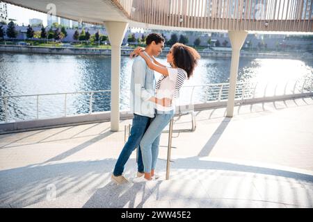 Foto a tutta lunghezza del corpo di vere relazioni tra studenti amanti che hanno un appuntamento romantico insieme sulle scale del fiume all'aperto Foto Stock