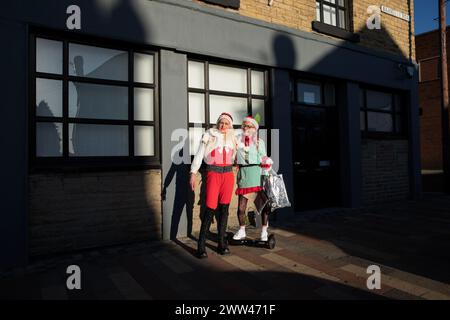 Tracey Decarolis (un residente di Goldhtorpe), vestita da Elfo e Amanda Wardle durante un tour di raccolta fondi nella Goldthorpe High Street in aiuto di un ragazzo locale con leucemia. L'ex città mineraria di Goldthorpe, Barnsley, South Yorkshire, Regno Unito. Foto Stock