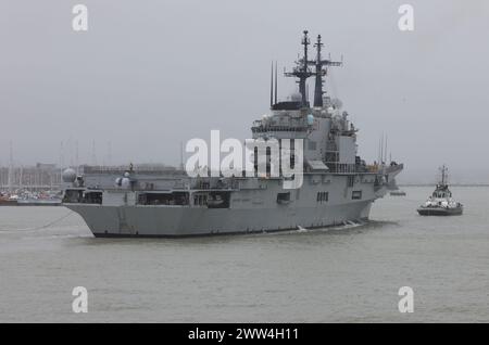 Un rimorchiatore guida l'aeromobile della Marina militare italiana che trasporta L'incrociatore GIUSEPPE GARIBALDI (C551) verso un ormeggio nella base navale Foto Stock