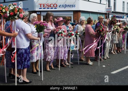 Neston Female Friendly Society Annual Club Walking Day. Neston Cheshire Regno Unito 2015. I membri del Ladies Club al "Cross" cantano inni e Land of Hope and Glory. Camminano con i loro bastoncini di fiori. HOMER SYKES anni '2010 Foto Stock